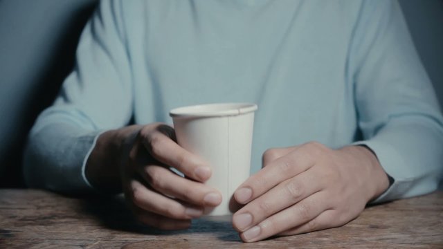 Young man drinking tea from a paper cup