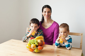 Fototapeta premium Happy healthy family drinking an orange jiuce
