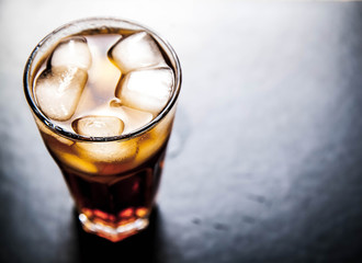 cola with ice on a wooden background. soft drinks
