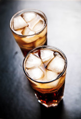 cola with ice on a wooden background. soft drinks