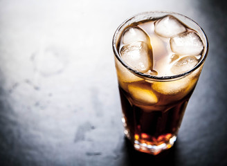 cola with ice on a wooden background. soft drinks