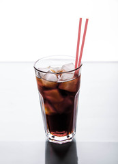 Cola in a glass with ice with red tube. soft drinks