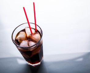 Cola in a glass with ice with red tube. soft drinks