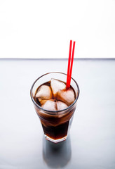 Cola in a glass with ice with red tube. soft drinks