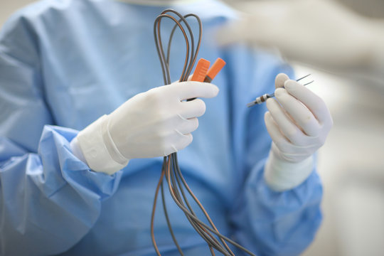 Surgeon's hands preparing coagulation wires for an operation