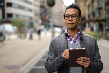 Young African Asian man in New York City using tablet pc