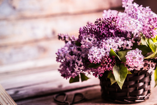 Bouquet of lilacs on wooden background