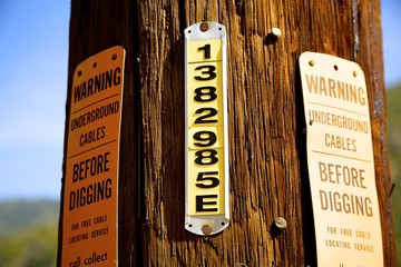 Signage on a wooden telephone pole.