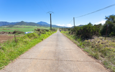 Fototapeta na wymiar chemin bétonné avec vue sur le Piton des Neiges, Réunion