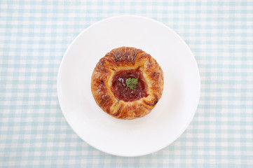 お皿にのせた 苺ジャム デニッシュパン テーブル