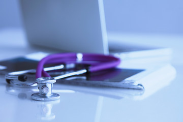 Violet stethoscope near laptop computer