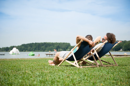 Paar entspannt im Liegestuhl am See