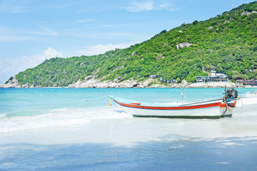 Boat on the shore of the blue ocean