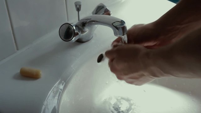  Man washing his hands at bathroom sink