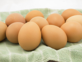 Eggs with cloth in basket on white background.