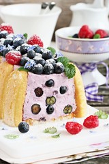 Homemade yogurt mousse cake ( charlotte ) with fresh berries.