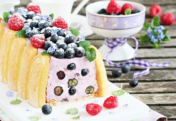 Homemade yogurt mousse cake ( charlotte ) with fresh berries.