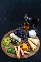 Cheese board with fresh grapes,herbs and olives