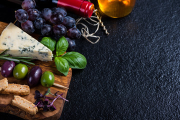 Food background,rustic board with cheese herbs and wine