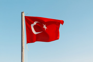 Turkish flag waving against a blue sky