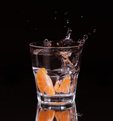 Slice of lemon splashing into a glass 