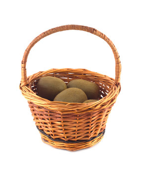Ripe kiwi fruits in brown wicker basket isolated on white