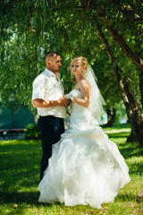 Bride with Groom at wedding Day walking Outdoors on spring