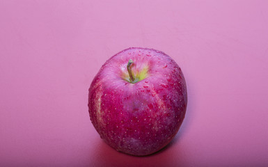 Fresh Red Apple on red cutting board, dripping with fresh water
