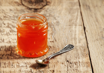 Apricot jam in a jar on the table, selective focus