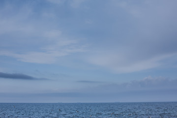 Hazy sunshine through a thick mist on a calm sea and blue skies