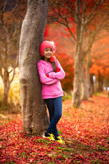 Adorable little asian girl at beautiful autumn park