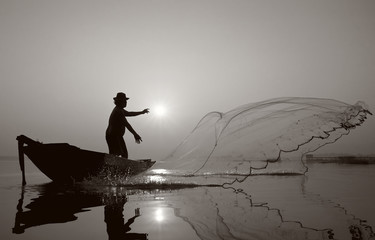 Fisherman of Bangpra Lake in action when fishing.(Sepia Style)