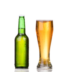 Chilled green bottle with condensate and a glass of beer