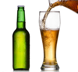 Chilled green bottle with condensate and a glass of beer