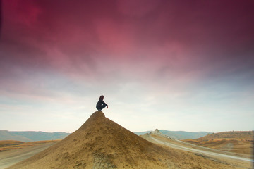 Silhouette of woman meditating on top of a hill