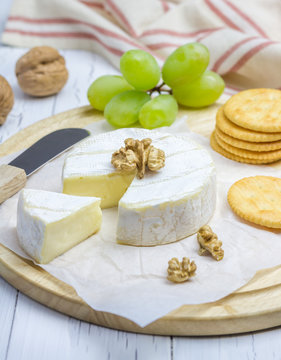 Soft brie cheese with sweet grapes, nuts and crackers