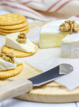 Soft brie cheese with crackers and nuts