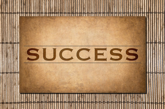 Success. The word on a stone and bamboo background