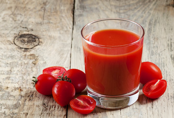 Fresh tomato juice and tomatoes on the table, selective focus