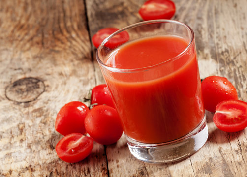 Fresh tomato juice and tomatoes on the table, selective focus