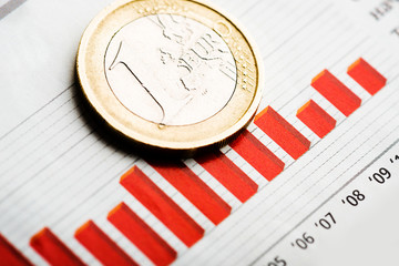 One euro coin on fluctuating graph. Rate of euro (shallow DOF)