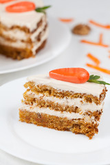 Sliced carrot cake with cream on white plate