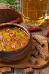 Bowl of rustic traditional chicken broth noodle soup with sausag