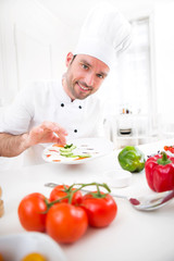 Young attractive professional chef cooking in his kitchen