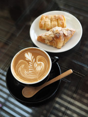 cup of coffee latte art on the wood desk