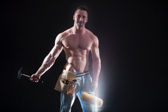 Sexy sixpack Mann als Heimwerker mit Farb Roller und Hammer Portr&auml;t