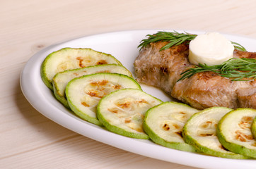 Pork steak, grilled, with melting butter and zucchini