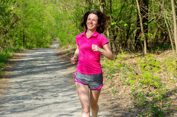 Woman runner jogging outdoors in forest, exercising concept

