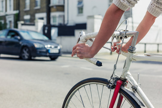 Young woman cycling on a road in the city