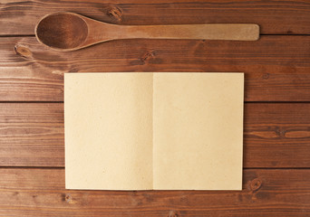Wooden spoon next to recipe book